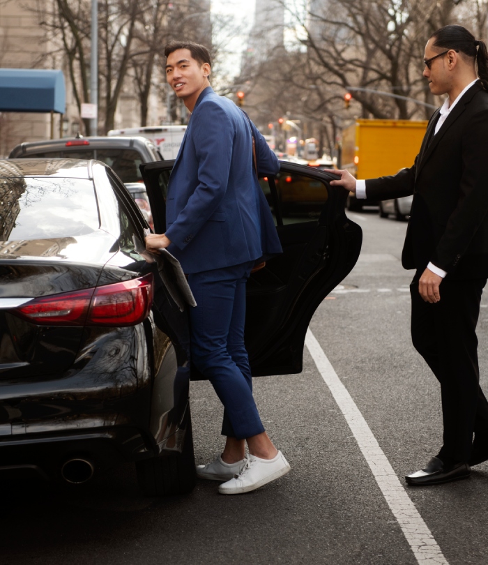 Taxi gare avec chauffeur ouvrant la porte à un passager en costume lors d’un déplacement professionnel.